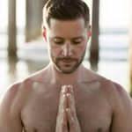 Brian Roy-Garland with hands joined in a yogic gesture.