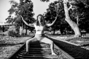 Dedicated yoga student in a pose on the railroad tracks.