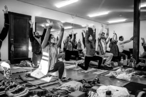 Yoga workshop students lift their arms overhead.