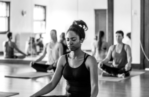 African American woman sitting in a yoga class meditating