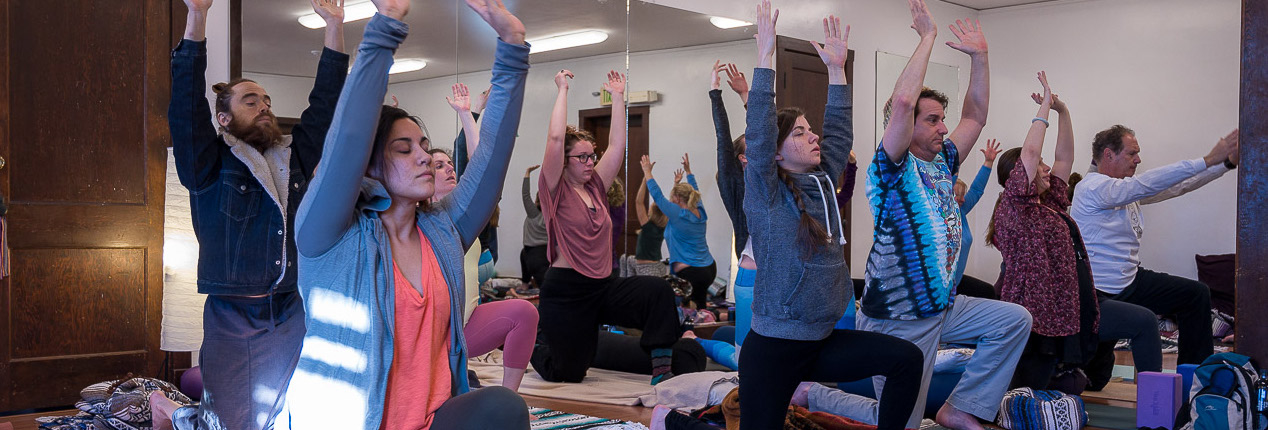 yoga workshop students raise arms overhead